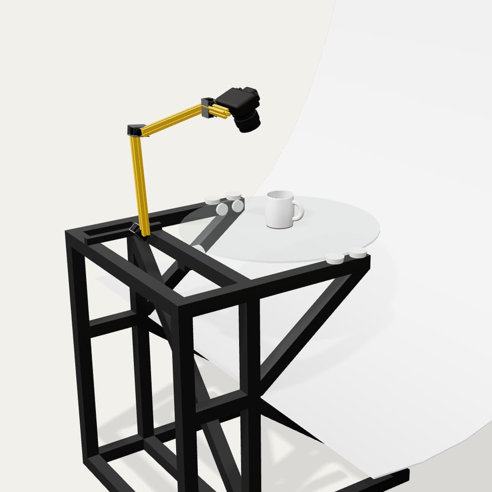 Kolovue render: graphite frame, glass platform, yellow robotic arm with a camera and a white sweep backdrop